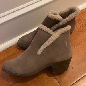 Taupe brown booties with fur lining the inside.
